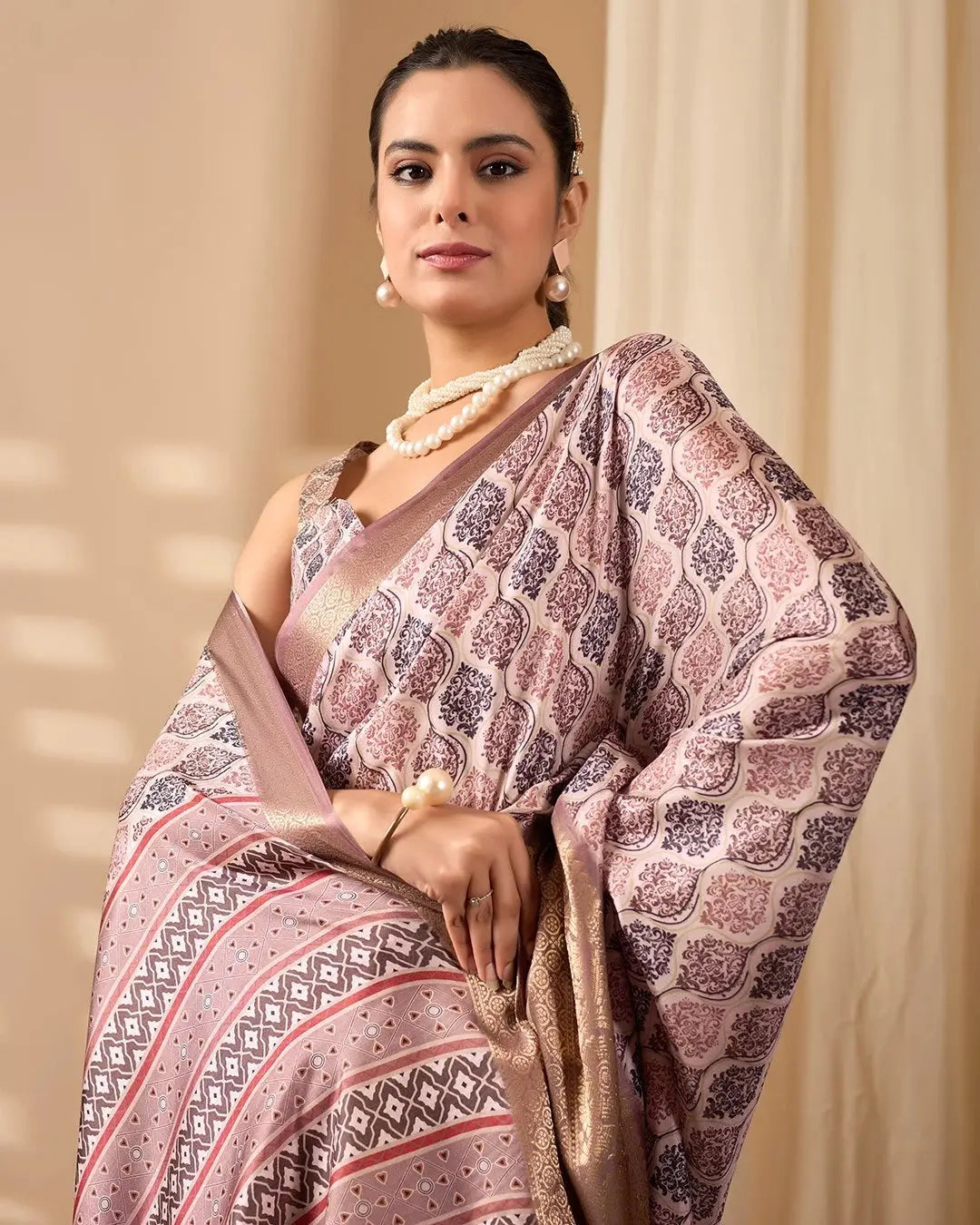 Woman wearing a patterned saree with a beige background
